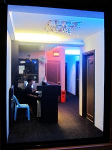 a man sitting at a desk in a room at Oriental Inn in Kuching