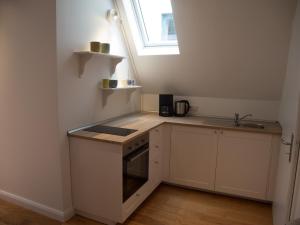 a small white kitchen with a sink and a window at Schönes Studio zentral in Bremen