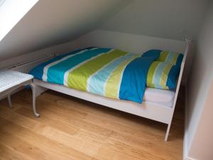 a white bunk bed with colorful sheets and a wooden floor at Schönes Studio zentral in Bremen