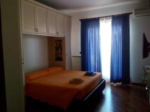 una camera con letto e finestra con tende blu di Mezzocammino Short Rent Apartment - CIU5125 a Mostacciano