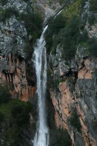 una cascata sul fianco di una scogliera di Apartamentos mirasierra plaza a Coto Ríos