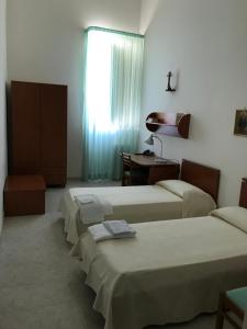 En eller flere senge i et værelse på Centro di Spiritualità Madonna della Nova