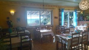 a dining room with tables and chairs and a window at Hotel La Croix des Bois in Lalizolle