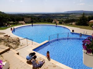 une grande piscine avec des personnes debout autour de celle-ci dans l'établissement Casa Atenes, à L'Estartit