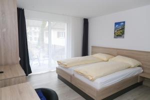 - une chambre avec un lit et une grande fenêtre dans l'établissement Hotel Traube Garni, à Küttigen