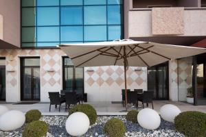 a patio with an umbrella in front of a building at Hotel Brandoli in Verona