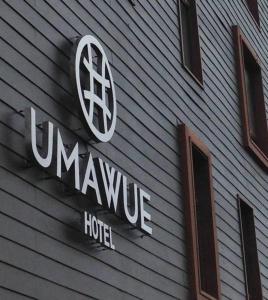 una señal en el lado de una casa con el logotipo de la tía en Hotel Umawue en Concepción