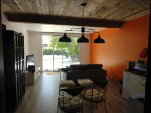 ein Wohnzimmer mit einem Sofa und einigen Stühlen in der Unterkunft Au Paradis des Grillons in Espinasses