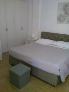 ポッツァッロにあるVilla Eva Bのベッドルーム(大きな白いベッド1台、スツール付)