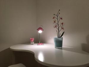 een tafel met een lamp en een vaas met bloemen erop bij Apartment in Sternschanze in Hamburg