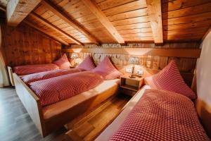 a room with three beds in a wooden room at Berggasthof Hochpröller in Sankt Englmar
