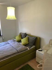 een slaapkamer met een bed met gele kussens en een kroonluchter bij 5min City Zentral - Wohnen am Werdersee Neustadt in Bremen