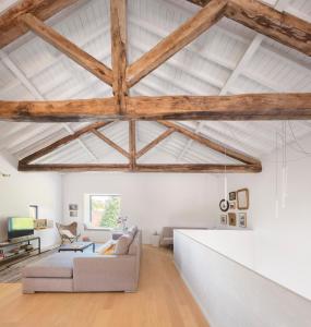 a living room with white walls and wooden beams at Pink House Azores in Ponta Delgada