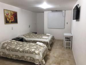 a room with two beds and a white screen at Apartamentos Don Bosco in Paso de los Libres