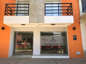 an orange and white building with a motorcycle in the window at Apartamentos Don Bosco in Paso de los Libres