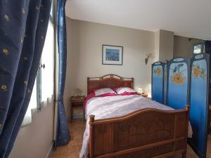 a bedroom with a bed with blue drapes at La porte bleue in Trouville-sur-Mer
