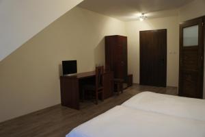 Un dormitorio con una cama y un escritorio con una computadora. en Pensjonat Perła Pienin, en Grywałd 20 fotos más