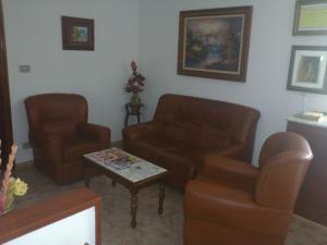 a living room with a couch and two chairs and a table at Hostal Fisterra in Lugo