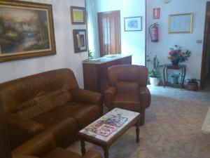 a living room with a couch and two chairs at Hostal Fisterra in Lugo