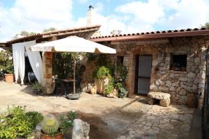 a stone house with an umbrella in front of it at Nepole Home Holiday in Torre Vado