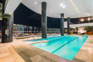 a swimming pool on the roof of a building at night at GHL Hotel Grand Villavicencio in Villavicencio
