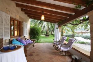 a patio with a couch and a table and chairs at Holiday home Can Pontico in Pollença