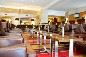 a restaurant with brown leather chairs and tables at Pestana Buenos Aires in Buenos Aires