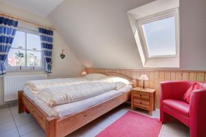 ブットヤーディンゲンにあるParadies-Ferien Burhave - Kat. IIのベッドルーム1室(ベッド1台、赤い椅子付)