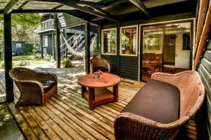 eine überdachte Veranda mit Korbstühlen und einem Tisch in der Unterkunft Hola Pucón in Pucón