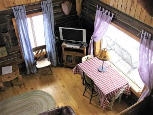 a room with a table and a television in a cabin at Grandpa's Cabin in Gardiner