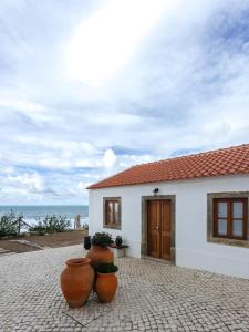 a white house with two large pots in front of it at Casa Nas Arribas in Sintra