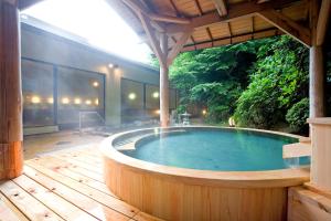 a jacuzzi tub in a patio with a wooden deck at Yumoto Fujiya Hotel in Hakone