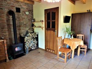 a room with a table and a wood stove at Sumówko Leśne Siedlisko in Zbiczno