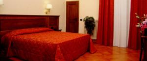 1 dormitorio con cama roja y cortinas rojas en Hotel California, en Florencia