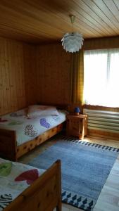 sypialnia z 2 łóżkami, oknem i żyrandolem w obiekcie Chalet Bergmann w mieście Bürchen
