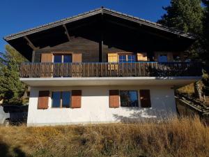 a house with a balcony on top of it at Chalet Bergmann in Bürchen