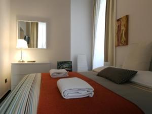 1 dormitorio con 1 cama con toallas en iBed Napoli B&B, en Nápoles
