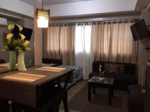 a living room with a dining room table and a couch at Montecarlo Sta Lucia 6J&k in Manila