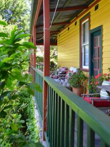 a porch of a yellow house with a green railing at No14 Lovel St in Katoomba