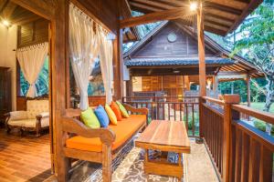 una veranda di una casa con divano e tavolo di Tirta Padi Villa Ubud ad Ubud