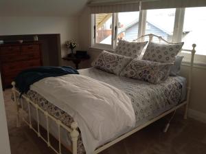 a bedroom with a bed with pillows and a window at Bindaree in Geelong