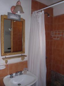 a bathroom with a white shower curtain and a sink at Casas de Juella in Tilcara
