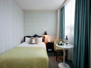 a bedroom with a bed and a table and a window at Central Tourist Hotel in Seoul