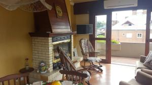 a living room with a fireplace with two rocking chairs at Apartamento Gramado in Gramado