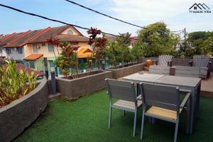 patio con tavolo e sedie sull'erba di Tropical Villa Kuantan a Kuantan