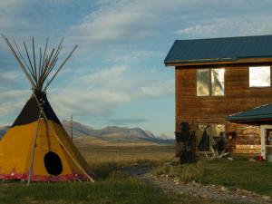 a yellow and red tent next to a house at Lodgepole Gallery in Browning