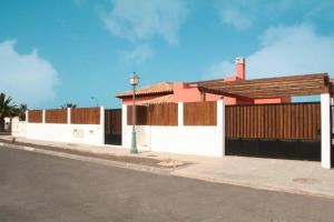 a white building with a gate and a street at Ereza Villas Alicia in Caleta De Fuste