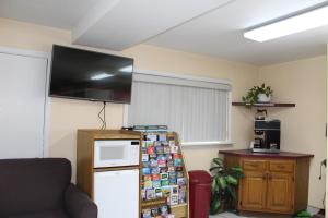 a kitchen with a refrigerator and a tv on the wall at Cascades Motel - Chattanooga in Chattanooga