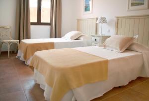 a hotel room with two beds and a window at Ereza Villas Alicia in Caleta De Fuste