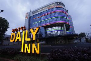 Hotel Daily Inn في جاكرتا: مبنى طويل مع علامة أمامه